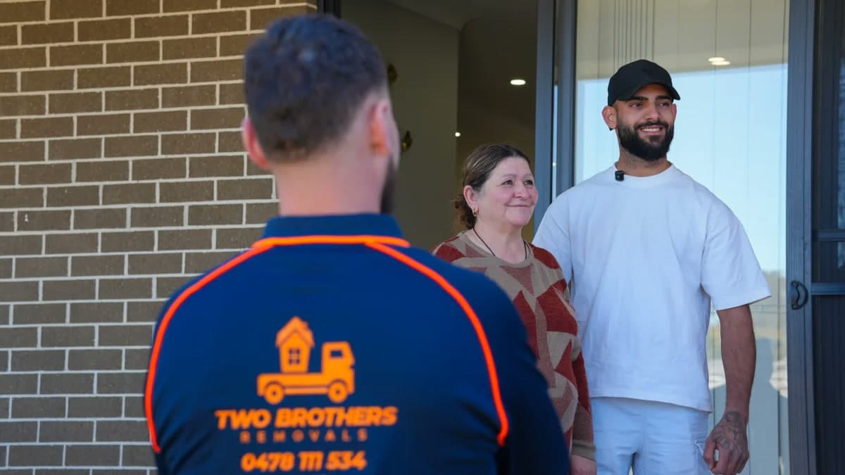 Two Brothers removalist greeting happy customers at the front entrance of their home