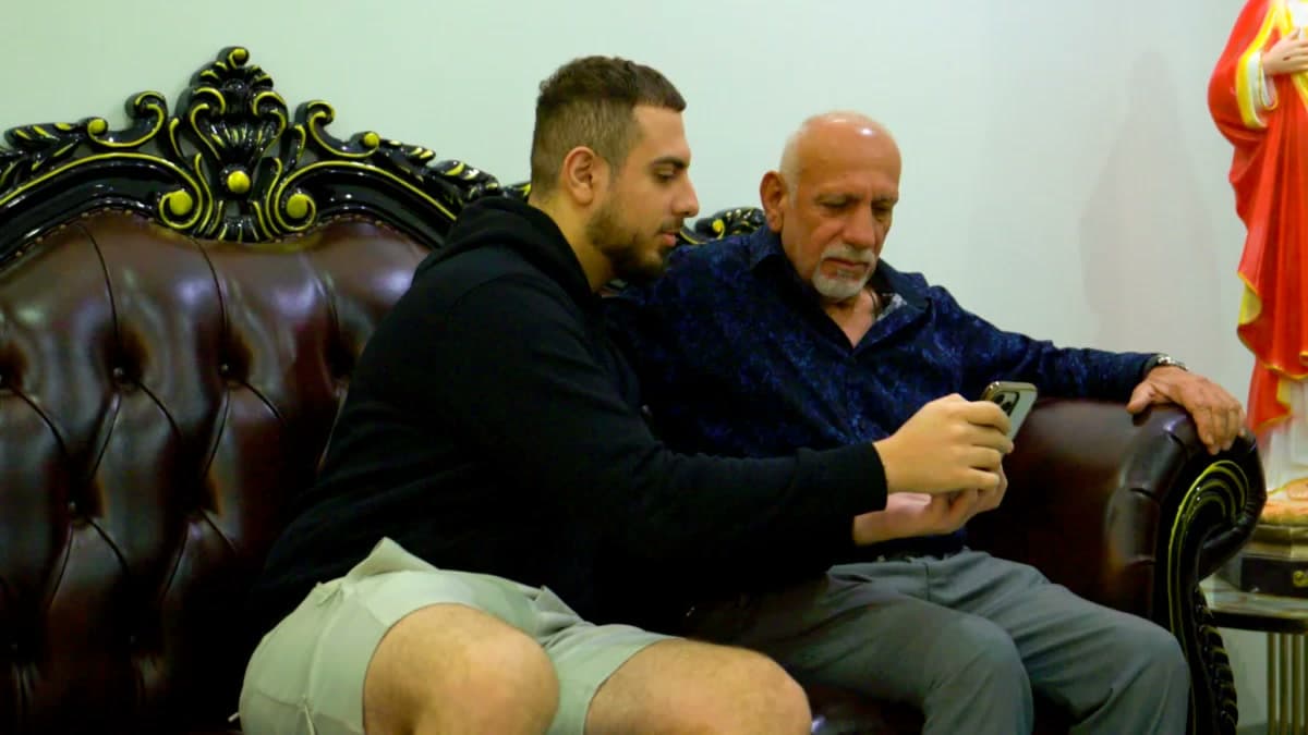 Customers sitting together on the sofa reviewing move details on a smartphone